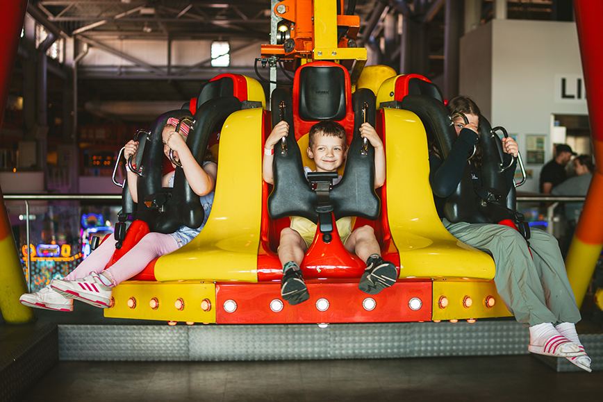 Children strapped in on a funfair ride